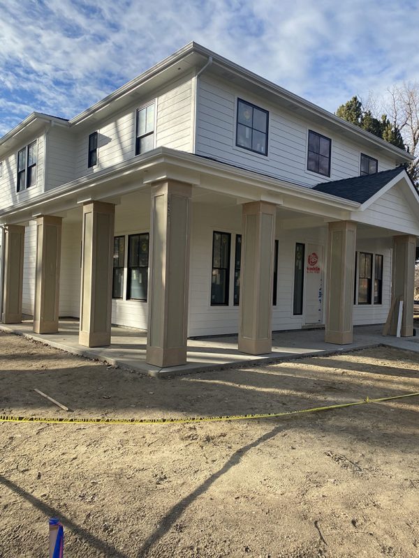 Two-story house with unfinished front porch and columns