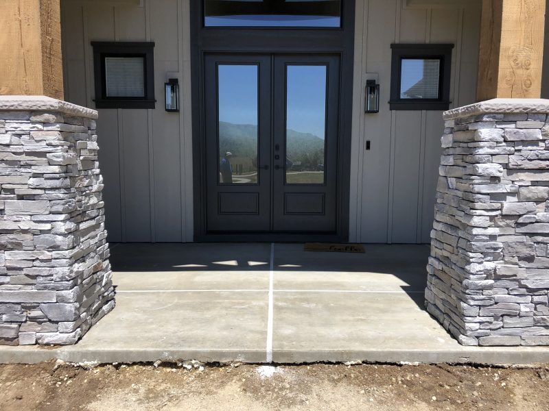 front porch pillars and concrete-entry work (image 1)