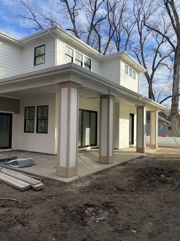 Two-story house with front porch and ungraded work area