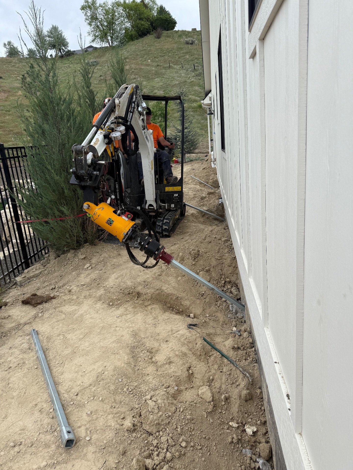 Installing helical tiebacks with a mini excavator