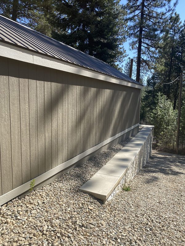 Completed shed side above retaining wall and gravel grade