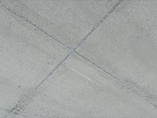 Intersecting control joints in light gray concrete