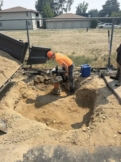 Soil being compacted with a rammer during sinkhole repair